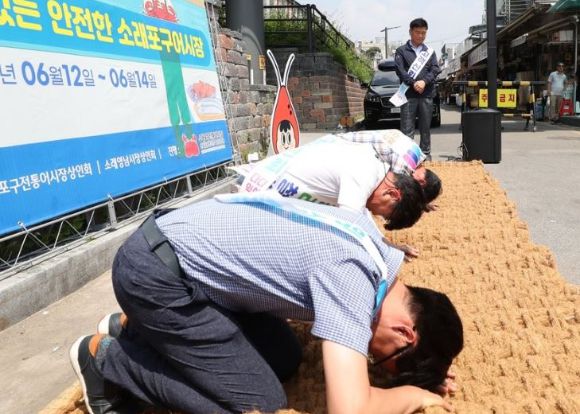 지난 2023년 6월 14일 인천시 남동구 소래포구 전통어시장에서 상인들이 자정대회를 열고 고객 신뢰 회복을 위한 사과 퍼포먼스를 하고 있다. [사진=연합뉴스]