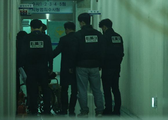 지난해 3월 7일 대전서부경찰서에서 첫 대면조사를 마친 대전 초등생 살해 교사 명재완이 조사실을 나오고 있다. 경찰들이 그를 유치장에 입감하기 위해 이동시키고 있다. [사진=연합뉴스]