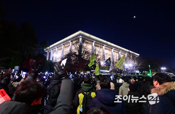 윤석열 대통령에 대한 탄핵소추안이 7일 국회 본회의에서 정족수 미달로 투표가 불성립된 가운데 윤 대통령 탄핵을 촉구하는 집회에 참석한 시민들이 집회가 끝난 후에도 국회를 둘러싸고 구호를 외치고 있다. [사진=정소희 기자]