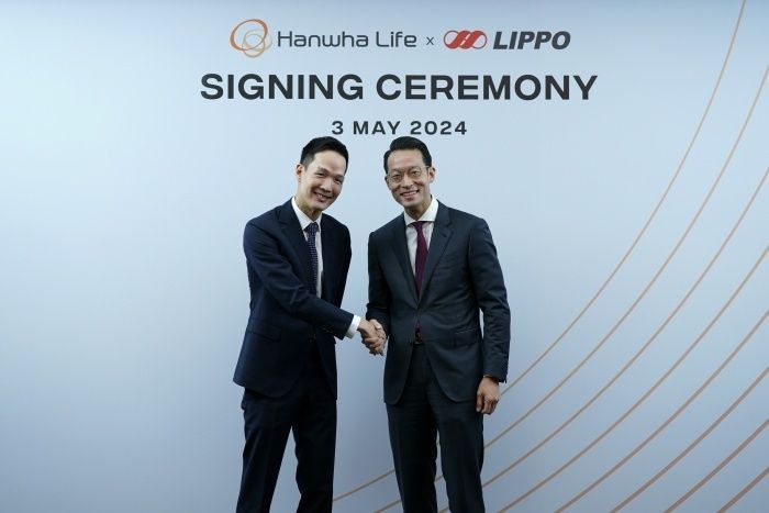 김승연 한화그룹 회장의 차남 김동원 한화생명 CGO 사장(왼쪽)이 인도네시아 노부은행 주식매매계약식에서 리포그룹 존 리아디 대표와 악수를 하며 기념촬영하고 있다. 사진ㅣ한화생명