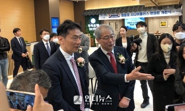 임종룡 우리금융그룹 회장(오른쪽)이 취임 직후인 2023년 3월말 당시 '우리은행 영등포 시니어플러스' 영업점 개점식에서 이복현 금감원장에게 영업점 내부를 설명하고 있다. 사진ㅣ인더뉴스