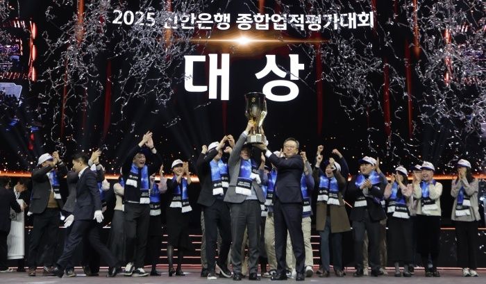 17일 인천 중구 인스파이어 엔터테인먼트 리조트아레나에서 열린 '2025년 종합업적평가대회'에서 정상혁 신한은행장(가운데 오른쪽)과 박현종 센터장(가운데 왼쪽)이 챔피언 트로피를 들어올리고 있다. 사진ㅣ신한은행