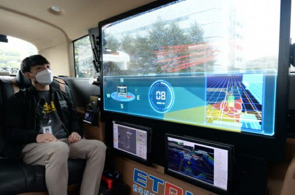ETRI 연구진이 개발한 자율주행 셔틀버스 '오토비' 내 투명 OLED 디스플레이로 AR 실감 가이드 기술을 시연하고 있다. (사진=ETRI)