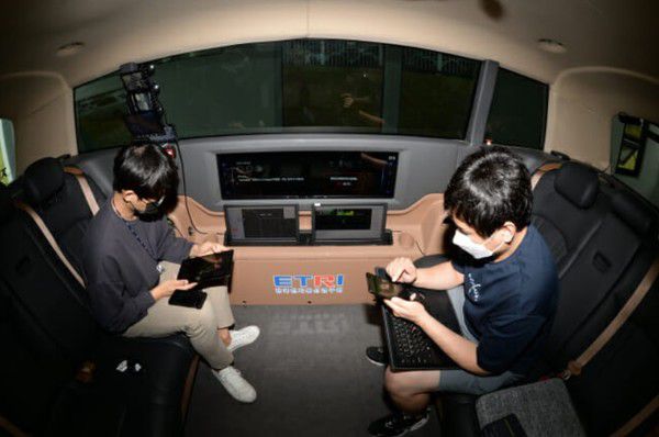 ETRI 연구진이 개발한 자율주행 셔틀버스 '오토비' 에서 운전에 신경쓰지 않고 다른 콘텐츠를 즐기고 있다. (사진=ETRI)