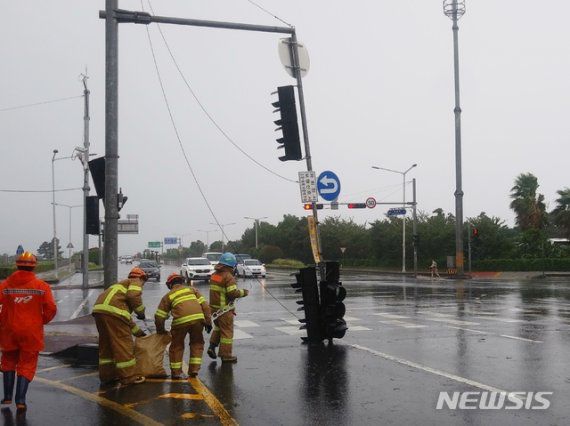 [제주=뉴시스] 강경태 기자 = 제8호 태풍 ‘바비’의 강풍으로 26일 오전 제주시 연동 마리나호텔 사거리에서 신호등이 도로에 쓰러져 출동한 소방대원들이 안전조치를 하고 있다. (사진=독자 제공) 2020.08.26. ktk2807@newsis.com /사진=뉴시스