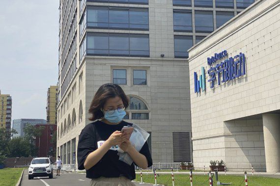 FILE - A woman uses her phone as she passes by the ByteDance headquarters in Beijing, China, on Friday, Aug. 7, 2020. The Chinese government is complicating the U.S.-government-ordered sale of U.S. TikTok assets. China on Friday, Aug. 28, 2020 introduced export restrictions on artificial intelligence technology, seemingly including the type that TikTok uses to choose which videos to spool up to its users. That means TikTok's Chinese owner, ByteDance, would have to obtain a license to export any restricted technologies to a foreign company. (AP Photo/Ng Han Guan) /뉴시스/AP /사진=뉴시스 외신화상