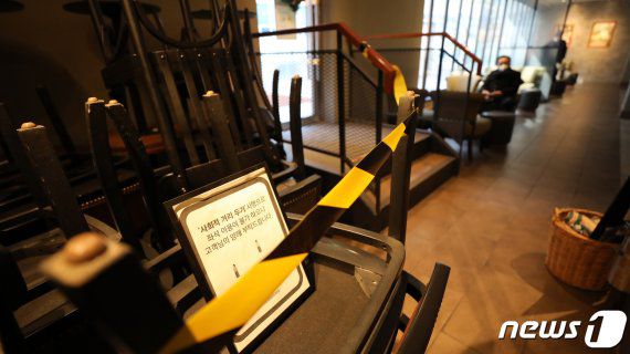 정부의 사회적 거리두기 2단계 시행을 하루 앞둔 지난 23일 서울의 한 카페 한켠에 의자와 테이블이 쌓여 있다. 뉴스1 제공