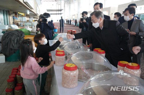 [신안=뉴시스]박영태 기자 = 문재인 대통령이 5일 오후 설 연휴 임시개통 예정인 전남 신안군 임자2대교에서 열린 세계 최대 해상풍력단지 48조원 투자협약식 체결 후 신안젓갈타운을 방문해 상인의 자녀들과 인사하고 있다. 2021.02.05. since1999@newsis.com /사진=뉴시스