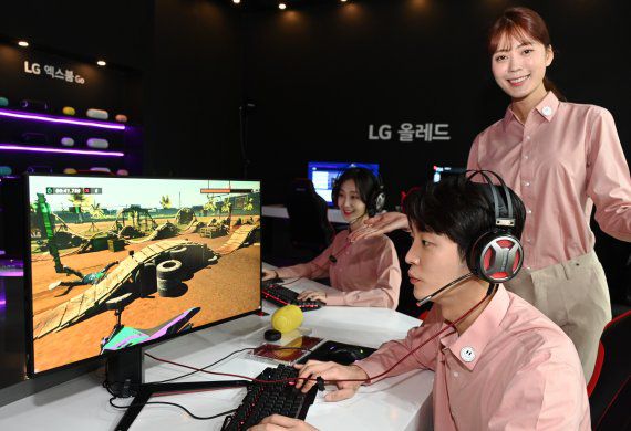 LG전자 모델들이 48형 LG 올레드 TV와 LG 울트라기어 게이밍 모니터로 최신 게임을 체험해보고 있다. LG전자 제공