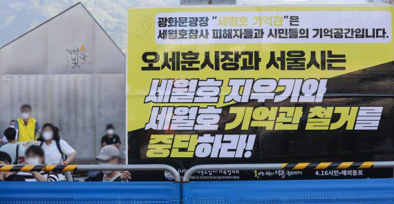 서울시가 광화문 광장 재구조화 공사를 위해 '세월호 기억공간' 철거를 통보한 26일 오전 서울 종로구 광화문 광장 세월호 기억공간 인근에서 관계자가 세월호 기억관 철거 중단 손팻말을 들고 있다. 뉴시스