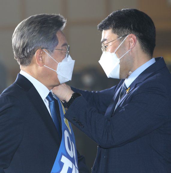 지난 12일 오후 이재명 더불어민주당 대선 경선 후보의 수행실장인 김남국 의원이 강원도 원주시 오크밸리 리조트 컨벤션홀에서 열린 제20대 대통령선거 후보자 선출을 위한 합동연설회에 행사장에서 어깨띠를 걸어주고 있다. 뉴시스 제공