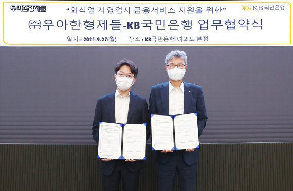 허인 KB국민은행장(오른쪽)과 김범준 우아한형제들 대표가 지난 27일 서울 여의도 KB국민은행 본점에서 '외식업 자영업자 금융서비스 지원을 위한 업무협약'을 체결한 후 기념촬영을 하고 있다. KB국민은행 제공