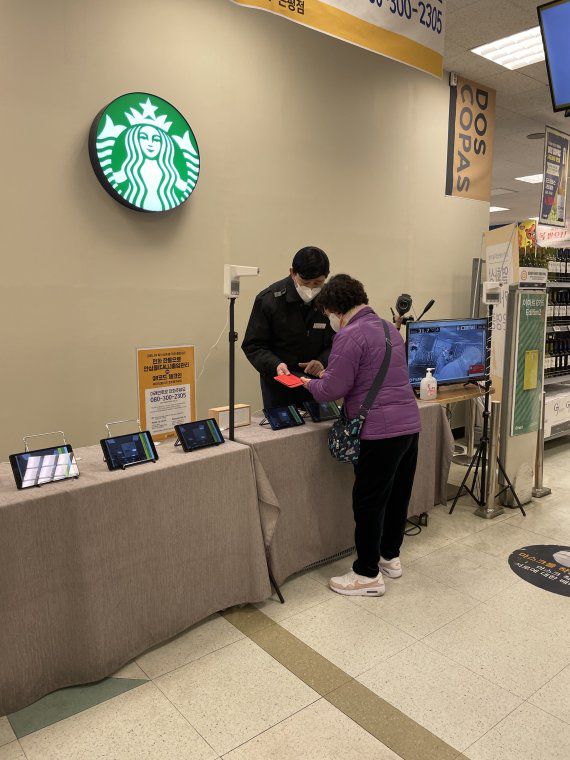 10일 오후 이마트 은평점에서 고객이 직원의 안내를 받아 방역패스 인증을 하고 있다. (사진=김주영 기자)