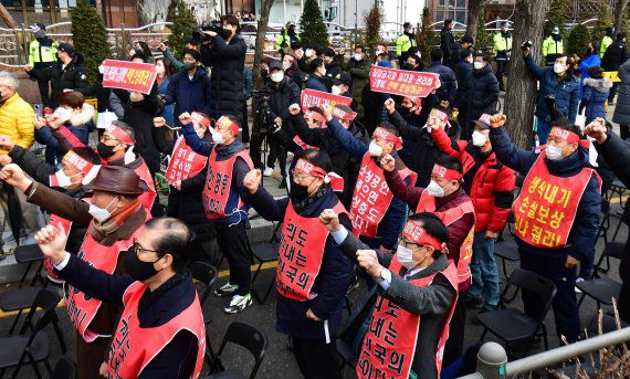 코로나 피해 자영업 총연대 회원들이 25일 서울 여의도 국회 앞에서 열린 ‘분노와 저항의 299인 릴레이 삭발식’에서 시위를 하고 있다.