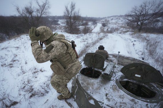 우크라이나 동부 루한스크 지역에서 28일(현지시간) 한 군인이 장갑차에서 뛰어내리고 있다. 미국은 러시아가 우크라이나 침공에 충분한 병력을 접경지대에 배치했다고 이날 경고했다. AP뉴시스