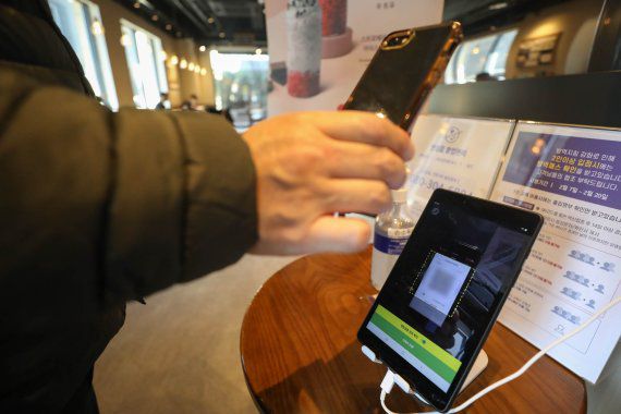 지난 18일 서울 강남의 한 카페에서 시민들이 입장 전 QR코드를 찍고 있다. 뉴스1 제공.