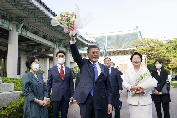 문재인 전 대통령이 어제 9일 청와대 본관 앞에서 직원에게 받은 꽃다발을 들어 보이고 있다. 김정숙 여사도 꽃을 받은 채 활짝 웃고 있다. /사진=청와대 제공