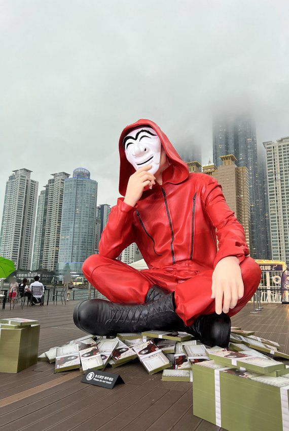 부산영상위원회는 넷플릭스에서 최근 공개한 '종이의 집: 공동경제구역'의 홍보를 위한 대형 조형물이 해운대구 더베이101에 설치됐다고 28일 밝혔다. 높이 4m 크기인 이 조형물은 오는 7월 10일까지 전시된다./제공=부산영상위원회