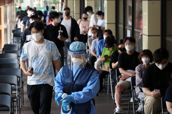 7만3천582명의 코로나19 신규 확진자가 발생, 83일 만에 최다를 기록한 19일 서울 송파구 보건소 선별진료소에서 시민들이 검사를 기다리고 있다.