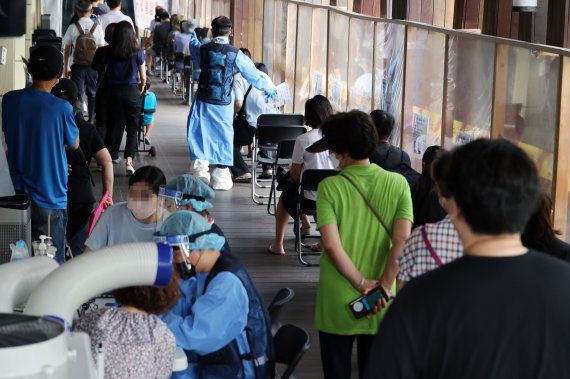 7만3천582명의 코로나19 신규 확진자가 발생, 83일 만에 최다를 기록한 19일 서울 송파구 보건소 선별진료소에서 시민들이 검사를 기다리고 있다.
