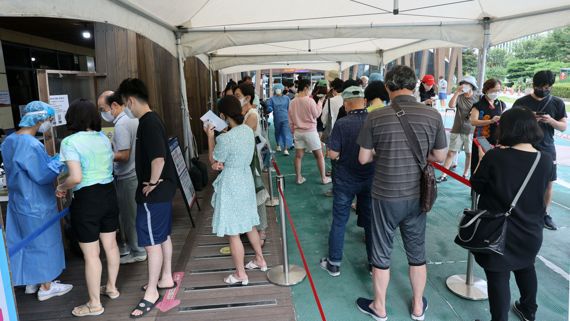 0시 기준 국내 코로나19 신규확진자가 11만933명으로 집계된 21일 오전 서울 송파구보건소 선별진료소를 찾은 시민들이 검사를 받기 위해 줄 서 있다. 사진=서동일 기자