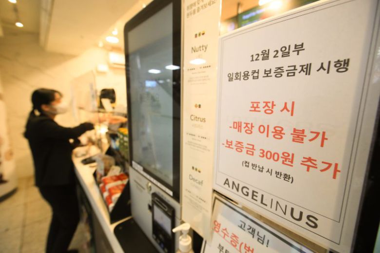 지난달 2일부터 제주에서 일회용컵에 음료를 받으려면 컵 보증금 300원을 지불해야 한다. 정부는 일회용 폐기물을 줄이기 위해 이날부터 제주와 세종에서 '일회용컵 보증금' 제도를 시범 실시한다. 사진은 보증금제 시행을 알리는 안내문이 게시된 제주국제공항내 프랜차이즈 매장 모습./뉴시스