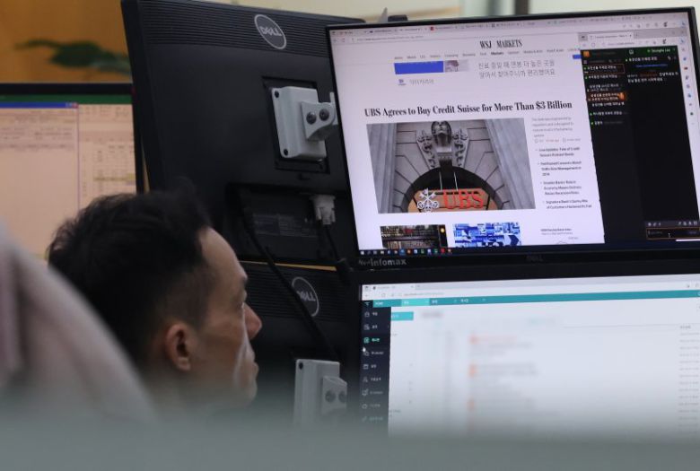 20일 오전 서울 중구 하나은행 딜링룸에서 한 직원이 위기설에 휩싸인 크레디트스위스(CS)를 인수한 스위스 최대 금융기관 UBS 관련 뉴스를 보고 있다. 연합뉴스