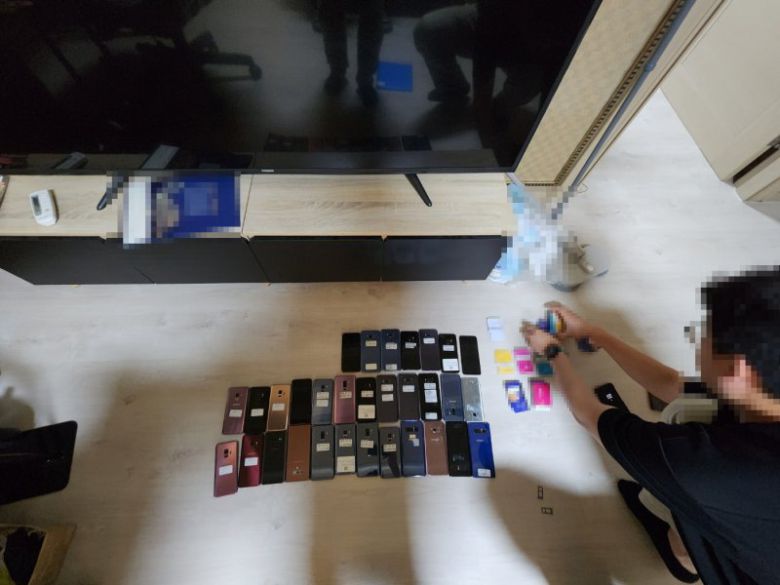 지난 6월 27일 경기도 수원에서 30대 자금세탁책을 체포하면서 현장에서 압수 조치한 휴대폰과 유심칩. 부산경찰청 제공