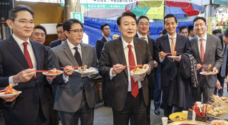 (부산=뉴스1) 부산사진공동취재단 = 윤석열 대통령이 6일 부산 중구 깡통시장을 방문해 박형준 부산시장과 이재용 삼성전자 회장, 구광모 LG그룹 회장, 조현준 효성그룹 회장, 김동관 한화그룹 부회장, 최재원 SK수석부회장 등 기업총수들과 함께 떡볶이 등을 맛보고 있다. 2023.12.6/뉴스1 /사진=뉴스1화상