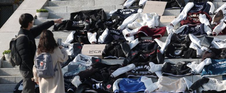 지난 5일 대구시 북구 경북대 본관 앞에서 재학생들이 경북대와 금오공대 통합을 반대하며 학과 점퍼를 벗어놓고 있다. 연합뉴스