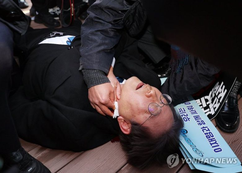 피습 당한 이재명 대표 (부산=연합뉴스) 손형주 기자 = 더불어민주당 이재명 대표가 2일 오전 부산 강서구 가덕신공항 부지를 둘러본 뒤 왼쪽 목 부위 피습을 당해 바닥에 누워 병원 호송을 기다리고 있다. 2024.1.2 handbrother@yna.co.kr(끝)