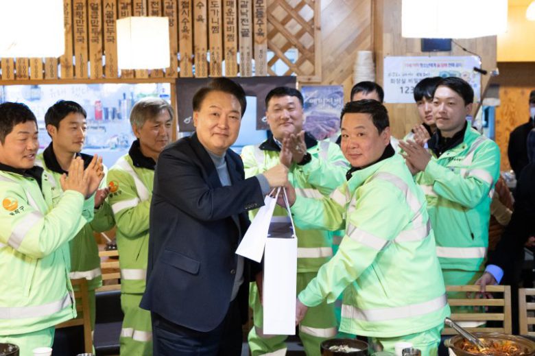 윤석열 대통령이 설 연휴 첫날인 9일 서울 동작구 한 식당에서 동작구 소속 가로청소 환경공무관들과 조찬을 함께하며 설 선물과 시계를 직접 선물하고 있다. 대통령실 제공