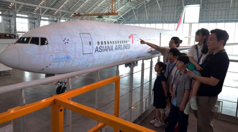 11일 인천 중구 아시아나항공 제2격납고에서 열린 아시아나항공-유니세프 사회공헌협약 30주년 기념행사에서 아시아나 임직원 가족들이 보잉 777 항공기에 유니세프 상징 블루라이트 조명이 비치는 것을 보고 있다.사진=박범준 기자