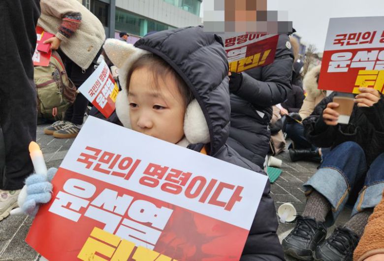 7일 전북 전주시 객사 앞 충경로에서 '윤석열 탄핵' 집회가 열린 가운데 7살 아이가 아빠와 함께 길거리로 나왔다. 사진=강인 기자