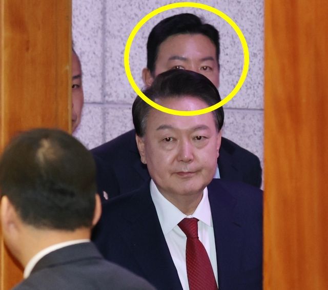 김성훈 대통령 경호처 차장이 지난 21일 서울 종로구 헌법재판소 대심판정에 출석한 윤석열 대통령을 경호 중이다. 노랑 원으로 표시된 인물이 김 차장. 연합뉴스