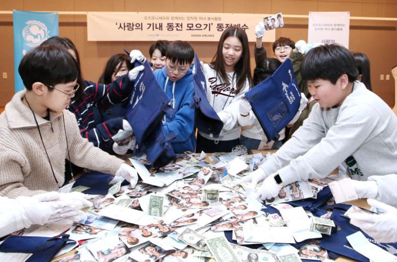 아시아나항공 임직원 자녀들이 20일 서울 강서구 아시아나항공 교육훈련동에서 '사랑의 기내 동전 모으기 캠페인'으로 모인 동전을 분류하고 있다. 아시아나항공 제공