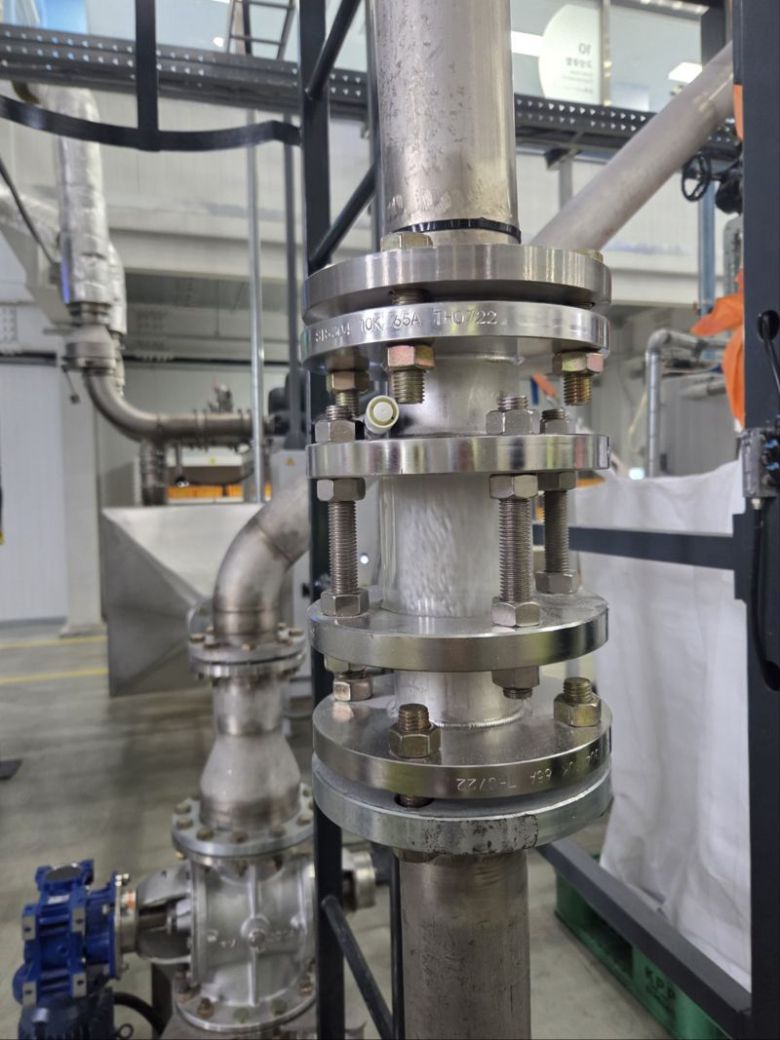 페트플레이크를 가공해 만든 동그란 알갱이 형태의 R칩이 '고상중합'을 통한 이물 제거를 위해 파이프로 이동하고 있다. 사진=홍요은 기자