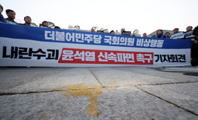 민주당 앞 계란 투척 흔적 (서울=연합뉴스) 신현우 기자 = 더불어민주당 박찬대 원내대표 등 소속 의원들이 20일 서울 종로구 헌법재판소 앞에서 기자회견을 열고 윤석열 대통령 신속 파면을 촉구하는 가운데 헌재 앞에 계란 깨진 자국이 남아 있다. 이날 오전 헌재 정문 앞에서 기자회견을 하던 더불어민주당 백혜련 의원이 계란에 맞았다. 2025.3.20 nowwego@yna.co.kr (끝) /사진=연합 지면화상