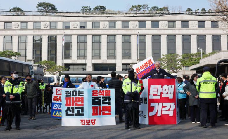 헌법재판소가 윤석열 대통령 탄핵소추 선고일을 오는 4일로 지정했다고 1일 공지했다. 이날 서울 종로구 헌법재판소 앞에서 국민의힘과 더불어민주당, 진보당 관계자들이 손팻말을 들고 1인 시위를 하고 있다. 연합뉴스