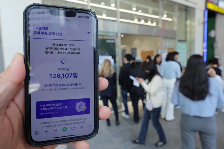 해킹 공격으로 가입자 유심 정보가 탈취된 SK텔레콤이 가입자 유심 무상 교체를 시작한 28일 오전 서울 종로구 T월드 매장 앞에서 직원들의 안내를 받아 온라인 예약을 하고 있다. /사진=뉴스1