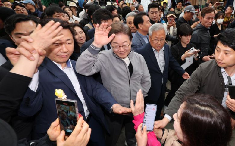 민심을 청취하는 '경청 투어'에 나선 이재명 더불어민주당 대선후보가 3일 강원도 양양군 양양시장에서 상인 및 주민들에게 인사를 하는 가운데 이 후보 경호원들 대인 직접 접촉을 차단하고 있다. /사진=뉴시스