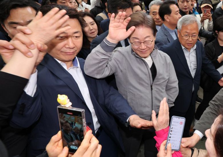 민심을 청취하는 '경청 투어'에 나선 이재명 더불어민주당 대선후보가 3일 강원도 양양군 양양시장에서 상인 및 주민들에게 인사를 하는 가운데 이 후보 경호원들 대인 직접 접촉을 차단하고 있다. 이 후보 측은 "후보에 대한 피습 모의 제보가 잇따르고 있다"고 밝혔다. 뉴시스