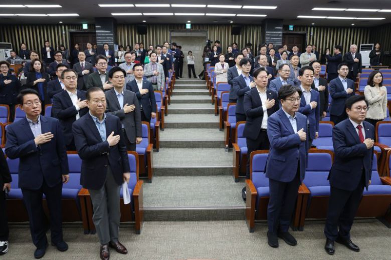 국민의힘 권영세 비상대책위원장과 권성동 원내대표을 비롯한 의원들이 6일 오후 서울 여의도 국회에서 열린 의원총회에서 국기에 경례를 하고 있다. 뉴스1