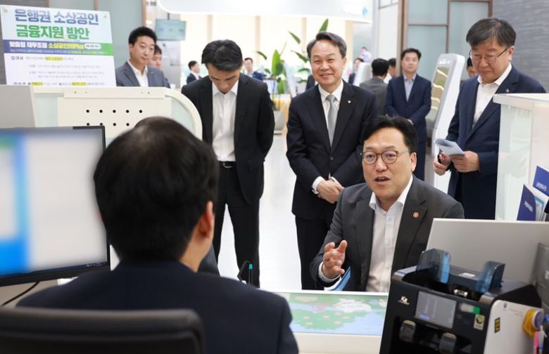 김병환 금융위원장이 8일 서울 중구 신한은행 본점에서 진옥동 신한금융그룹 회장(둘째줄 왼쪽 두번째부터), 이재연 서민금융진흥원 등과 함께 은행권 소상공인 금융지원 방안의 시행 현장을 점검하고 있다. 금융위원회 제공