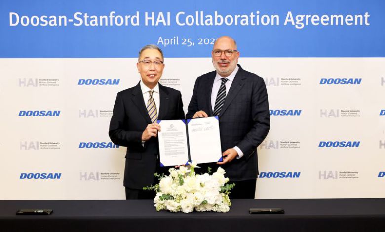 박지원 두산그룹 부회장(왼쪽)이 지난달 25일 동대문 두산타워에서 열린 산학협력 협약식에서 제임스 랜데이 스탠포드대 HAI연구소 공동연구소장과 기념촬영을 하고 있다. 두산그룹 제공