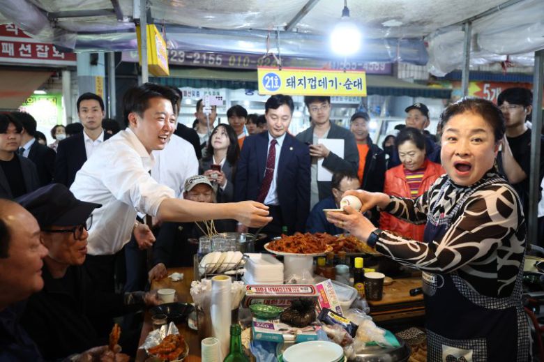이준석 개혁신당 대선 후보가 16일 충남 천안중앙시장에서 유세 도중 한 상인이 건넨 막걸리를 받고 있다. 연합뉴스