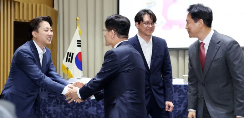 오세훈 서울시장(오른쪽 첫 번째)이 19일 오전 서울 중구 서울시청에서 열린 '약자와 동행하는 서울 토론회'에서 이준석 개혁신당 대통령 후보(왼쪽 첫 번째)와 김문수 국민의힘 대통령 후보가 악수를 나누는 모습을 지켜보고 있다. 뉴스1