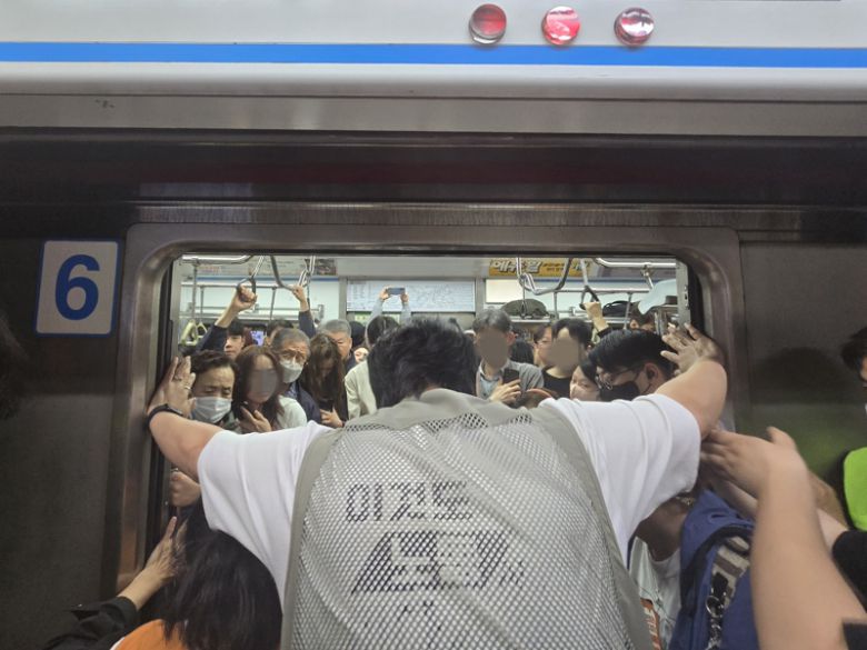 21일 오전 전국장애인차별철폐연대(전장연)가 출근길 지하철 탑승 시위를 열고 있다. 시위대가 추가 탑승을 위해 출입문이 닫히지 않도록 양손으로 문을 잡으며 실랑이가 벌어졌다. 대치가 계속된 탓에 출입문은 닫혔다 열리기를 반복했다. /사진=서지윤 기자