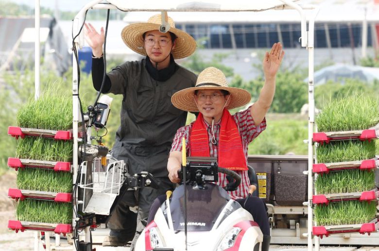 김문수 국민의힘 대통령 후보가 21일 경기 고양시 한 논에서 청년 농업인과 이앙기를 타고 손을 흔들고 있다. 뉴스1