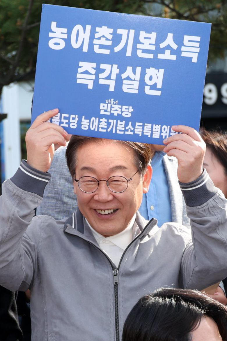 이재명 더불어민주당 대선후보가 3일 강원도 삼척시 삼척해수욕장 인근에서 농어촌기본소득 즉각실현이라고 적힌 손팻말을 들어 보이고 있다. 사진=뉴시스